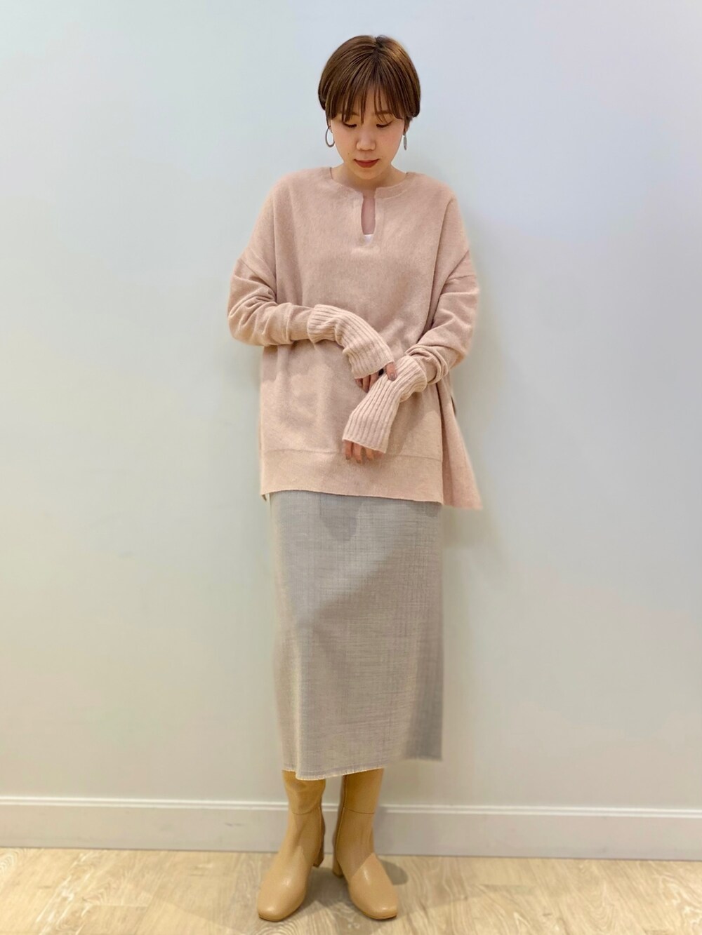 ベージュ系のブーツ、ピンク系のニット/セーター、グレー系のスカートを着用したレディースの冬コーディネートの2枚目の写真