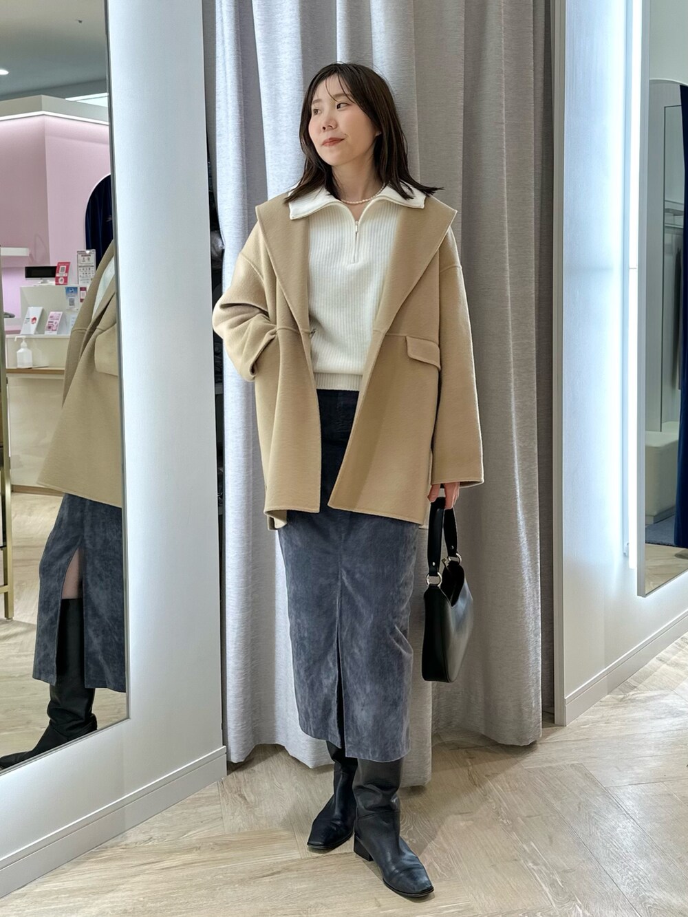 イエロー系のダッフルコート、グレー系のスカート、ホワイト系のニット/セーターを着用したレディースの秋コーディネートの6枚目の写真