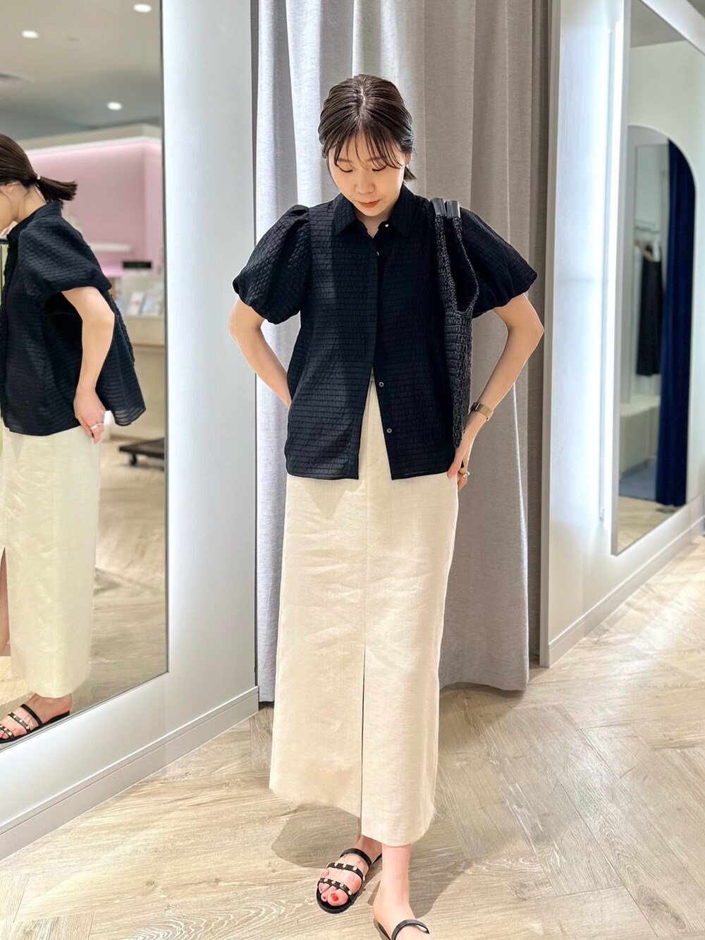 ベージュ系のスカート、ブラック系のシャツ/ブラウス、ブラック系のかごバッグを着用したレディースの夏コーディネートの6枚目の写真