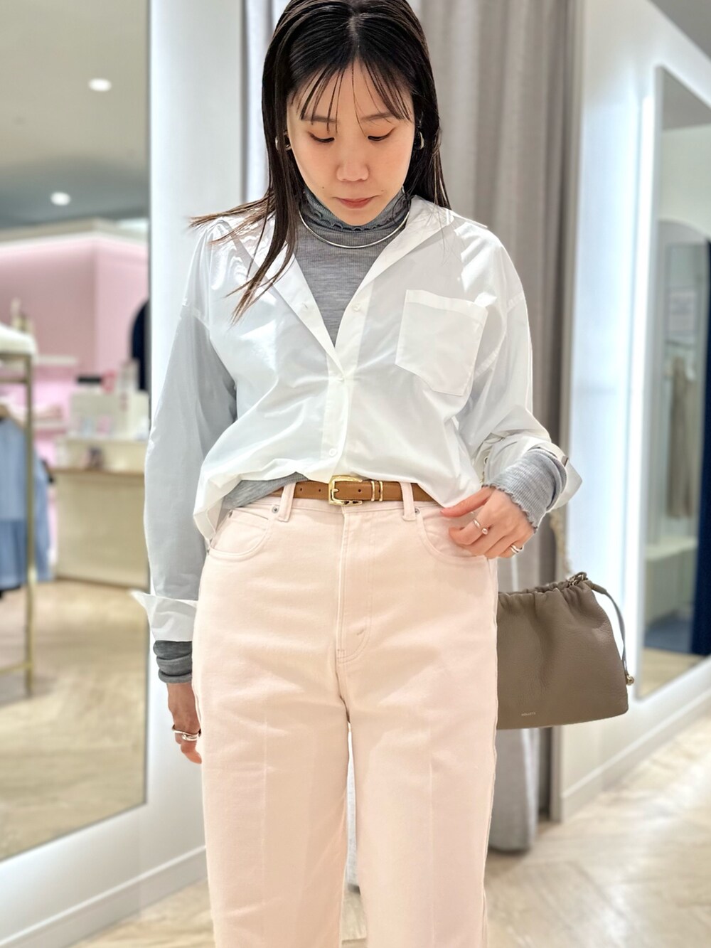 ピンク系のデニムパンツ、ホワイト系のシャツ/ブラウス、グレー系のTシャツ/カットソーを着用したレディースの冬コーディネートの3枚目の写真