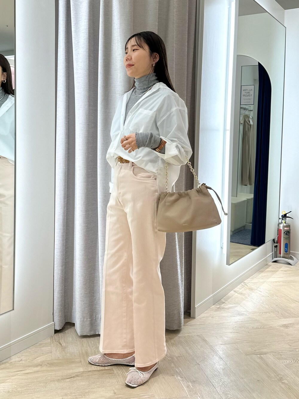 ピンク系のデニムパンツ、ホワイト系のシャツ/ブラウス、グレー系のTシャツ/カットソーを着用したレディースの冬コーディネートの2枚目の写真