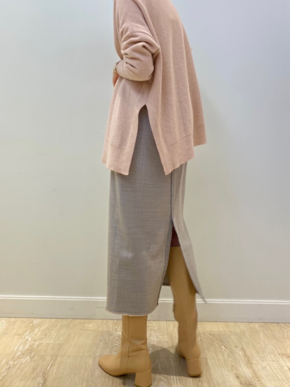 ベージュ系のブーツ、ピンク系のニット/セーター、グレー系のスカートを着用したレディースの冬コーディネートの5枚目の写真