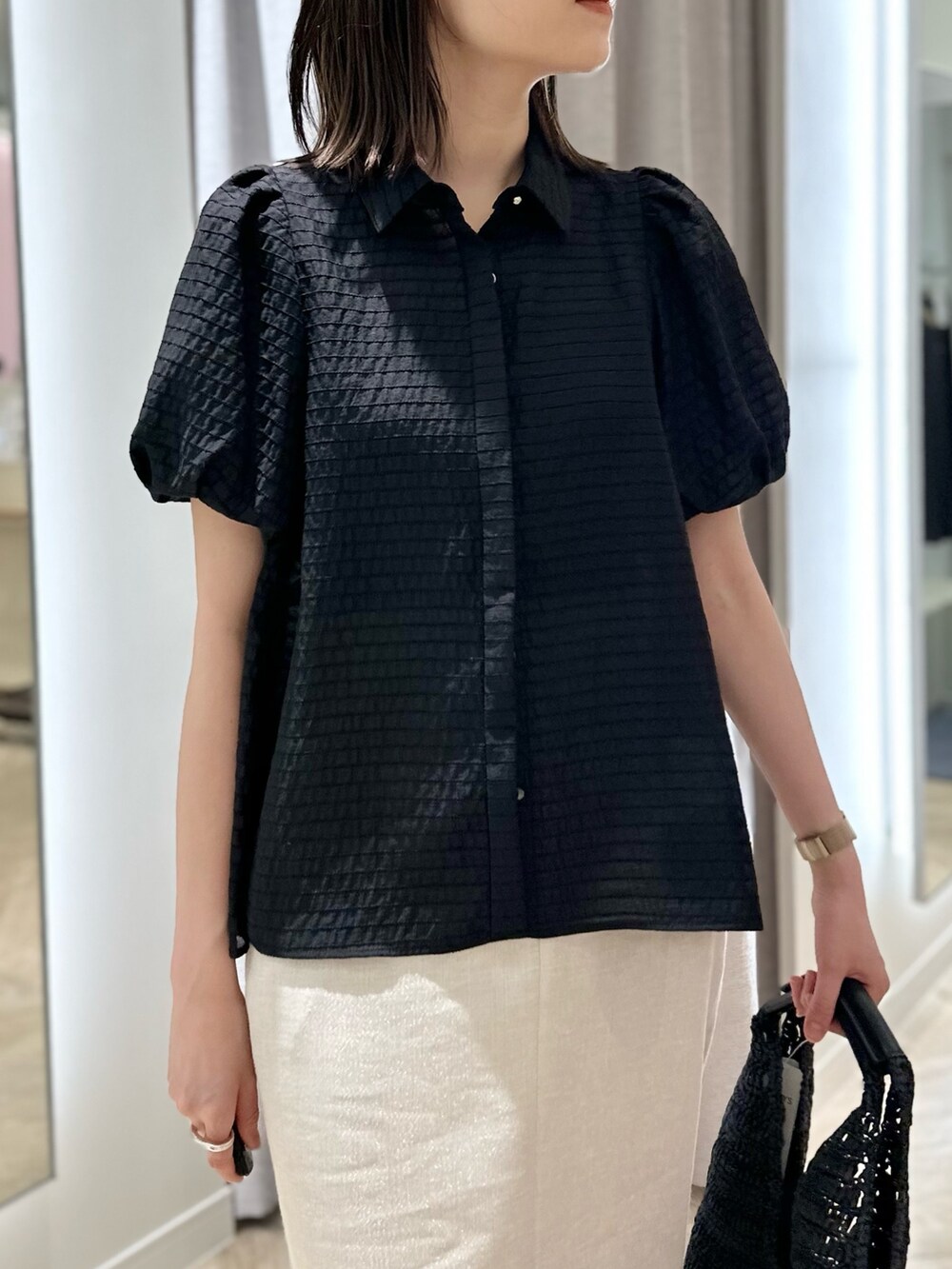 ベージュ系のスカート、ブラック系のシャツ/ブラウス、ブラック系のかごバッグを着用したレディースの夏コーディネートの5枚目の写真