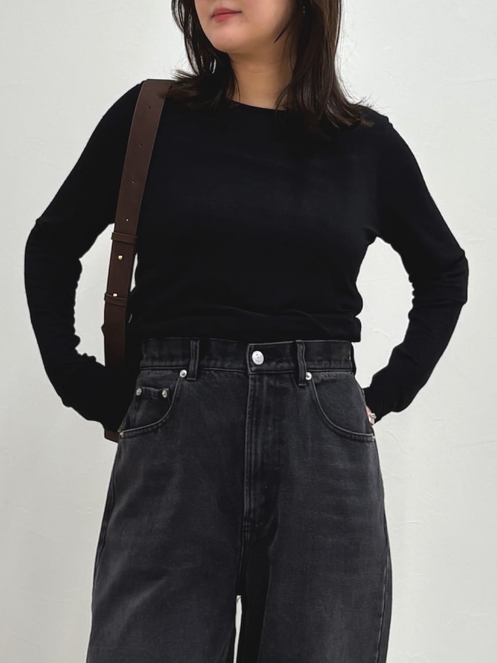 ブルー系のデニムパンツ、ブラック系のTシャツ/カットソー、ブラウン系のショルダーバッグを着用したレディースの夏コーディネートの4枚目の写真