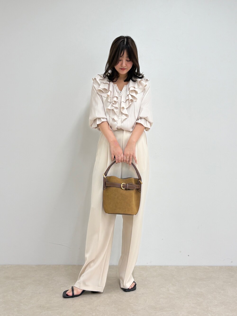ホワイト系のシャツ/ブラウス、ホワイト系のスラックス、ブラウン系のショルダーバッグを着用したレディースの夏コーディネートの2枚目の写真
