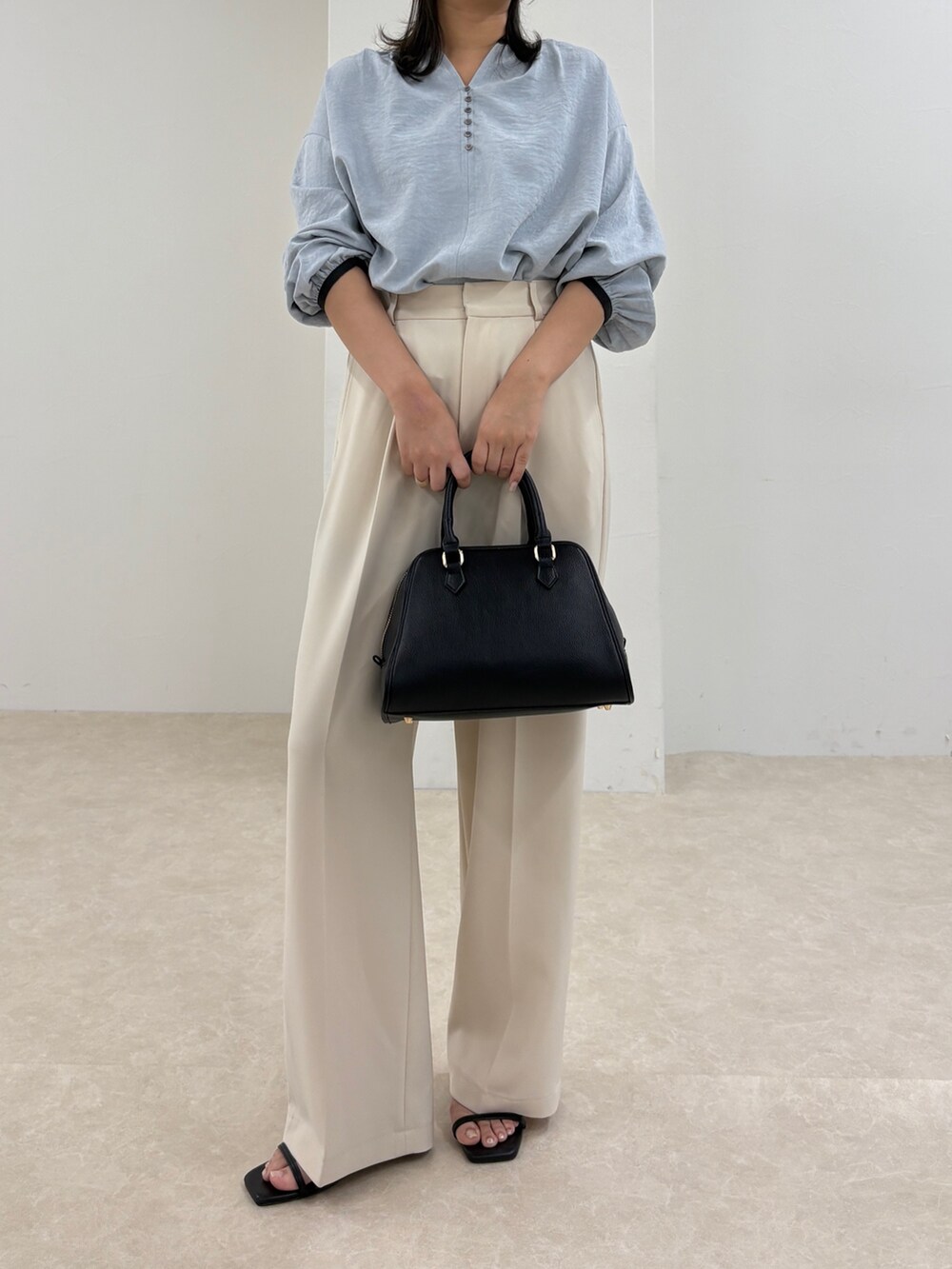 ブルー系のシャツ/ブラウス、ホワイト系のスラックス、ブラック系のショルダーバッグを着用したレディースの秋コーディネートの5枚目の写真