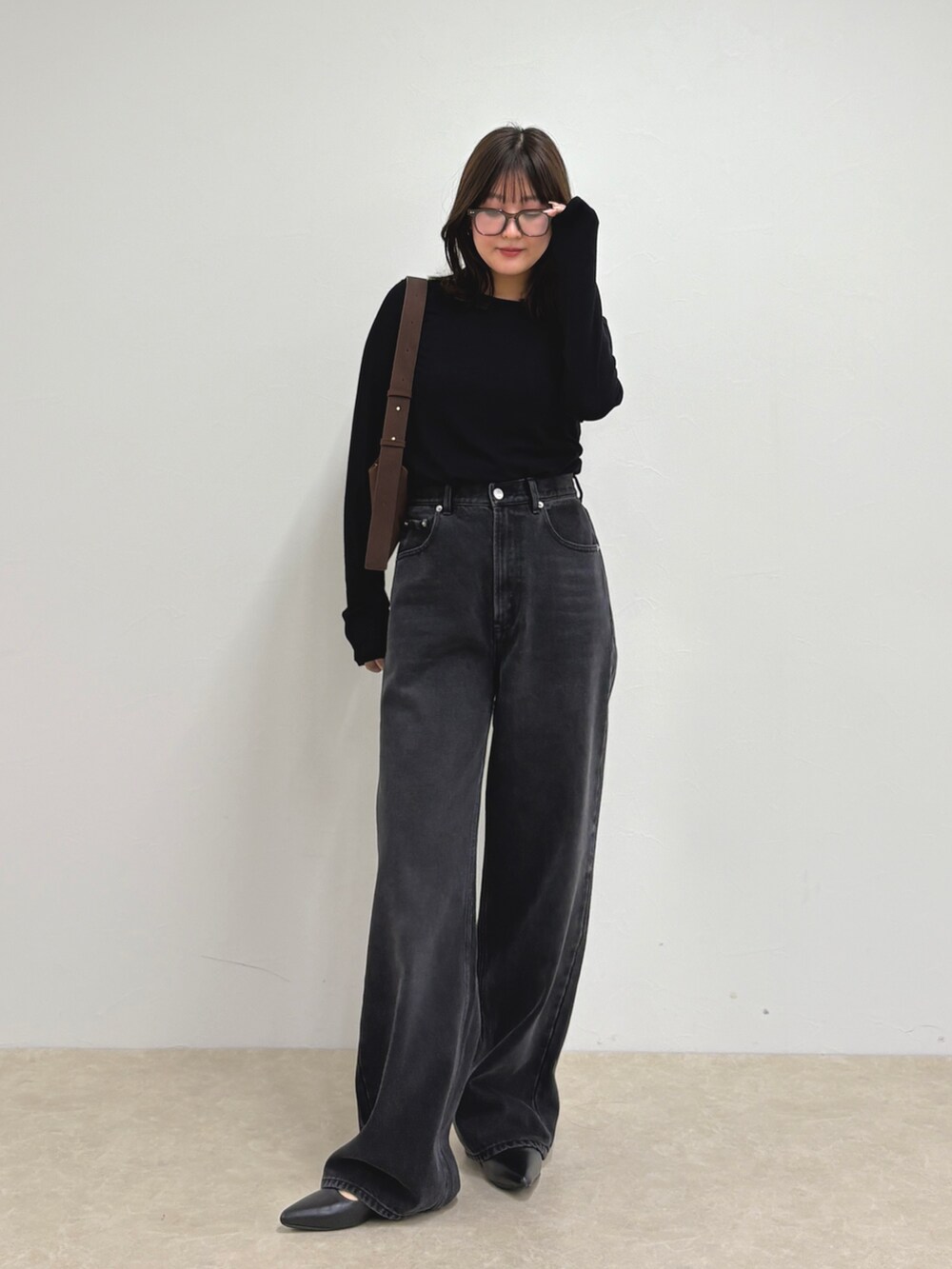 ブルー系のデニムパンツ、ブラック系のTシャツ/カットソー、ブラウン系のショルダーバッグを着用したレディースの夏コーディネートの7枚目の写真