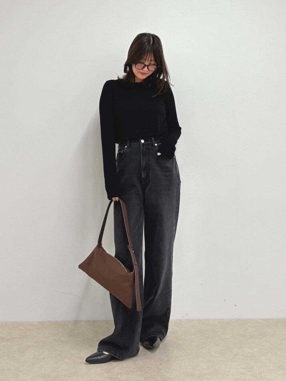 ブルー系のデニムパンツ、ブラック系のTシャツ/カットソー、ブラウン系のショルダーバッグを着用したレディースの夏コーディネートの6枚目の写真