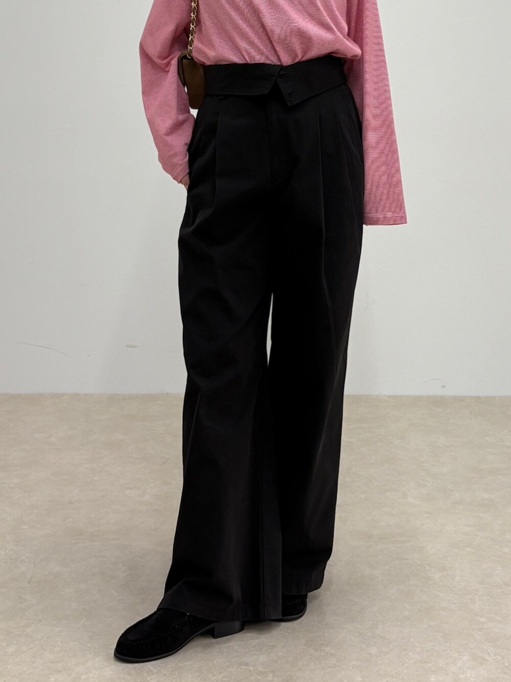 ブラック系のチノパンツ、レッド系のTシャツ/カットソー、ブラウン系のショルダーバッグを着用したレディースの秋コーディネートの5枚目の写真