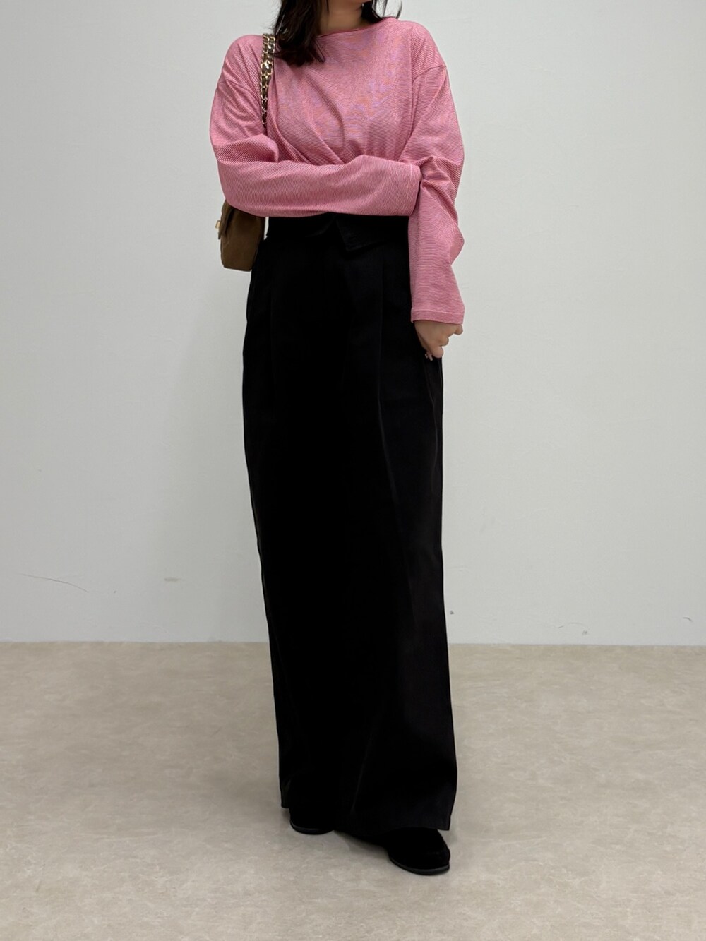 ブラック系のチノパンツ、レッド系のTシャツ/カットソー、ブラウン系のショルダーバッグを着用したレディースの秋コーディネートの2枚目の写真