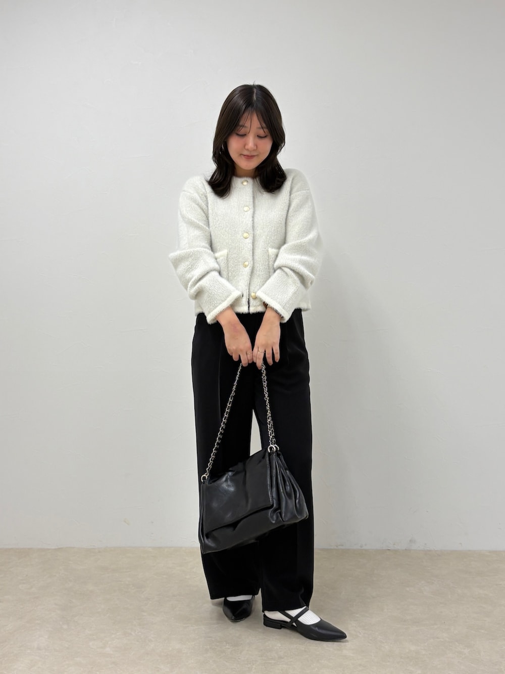 ブラック系のスラックス、ホワイト系のカーディガン/ボレロを着用したレディースの秋コーディネートの4枚目の写真