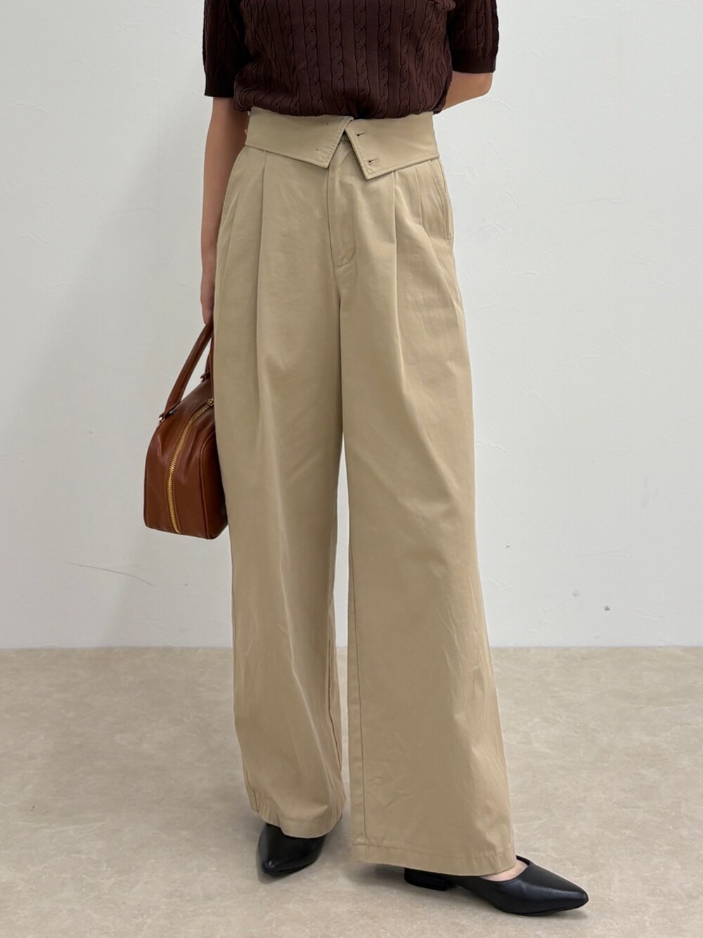 ブラウン系のニット/セーター、ベージュ系のチノパンツ、イエロー系のショルダーバッグを着用したレディースの夏コーディネートの5枚目の写真