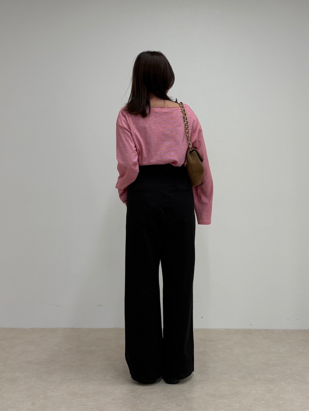 ブラック系のチノパンツ、レッド系のTシャツ/カットソー、ブラウン系のショルダーバッグを着用したレディースの秋コーディネートの3枚目の写真