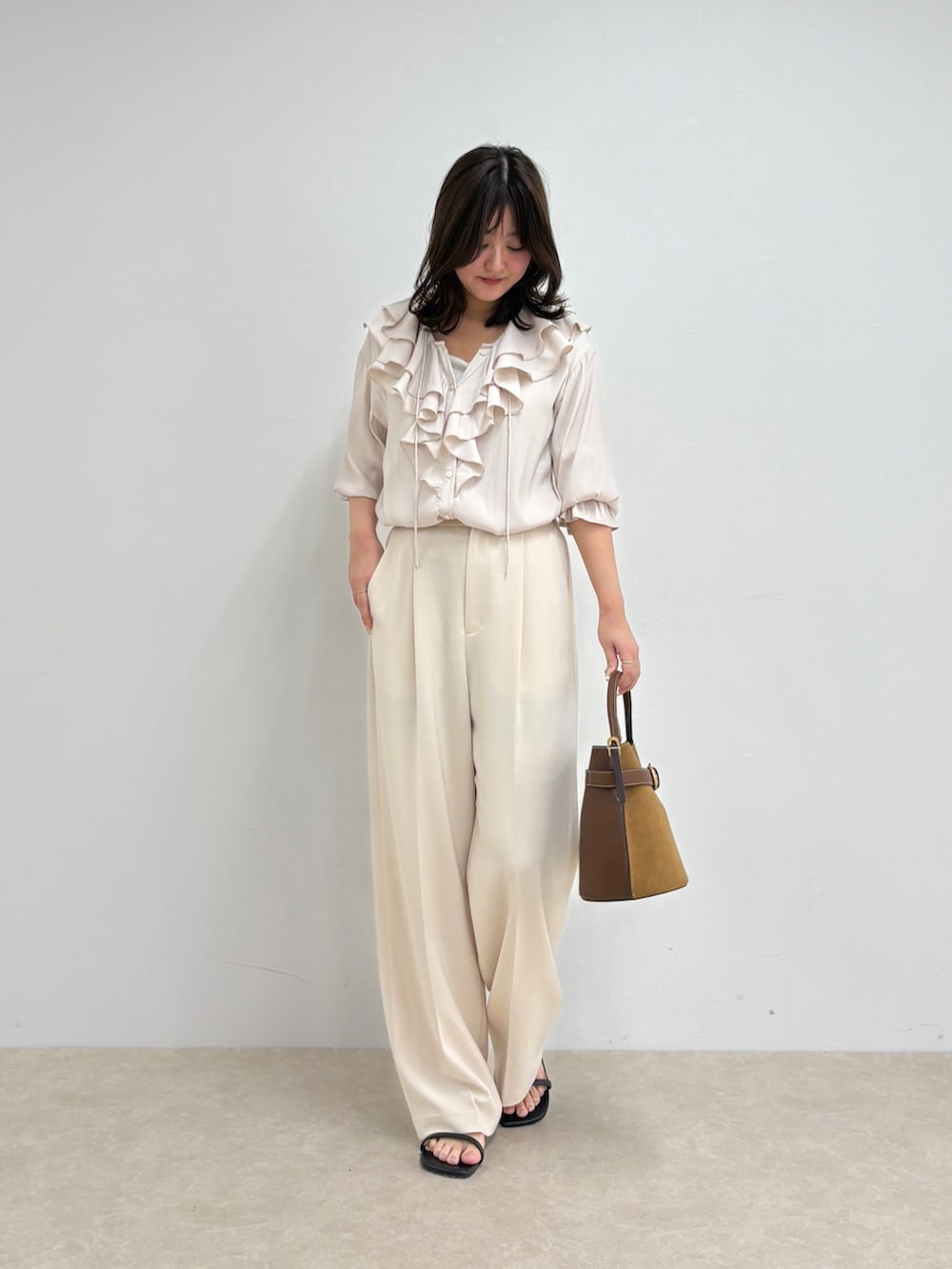 ホワイト系のシャツ/ブラウス、ホワイト系のスラックス、ブラウン系のショルダーバッグを着用したレディースの夏コーディネートの6枚目の写真