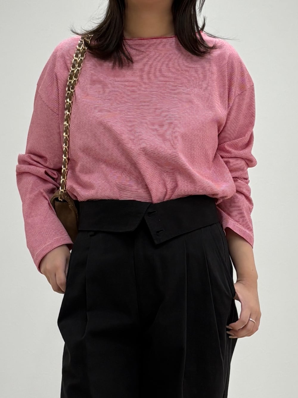 ブラック系のチノパンツ、レッド系のTシャツ/カットソー、ブラウン系のショルダーバッグを着用したレディースの秋コーディネートの4枚目の写真