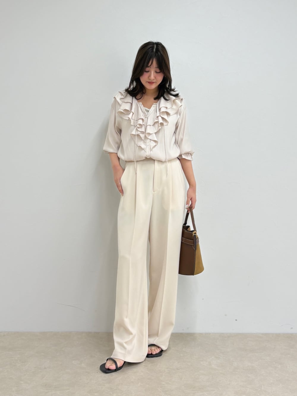 ホワイト系のシャツ/ブラウス、ホワイト系のスラックス、ブラウン系のショルダーバッグを着用したレディースの夏コーディネートの7枚目の写真