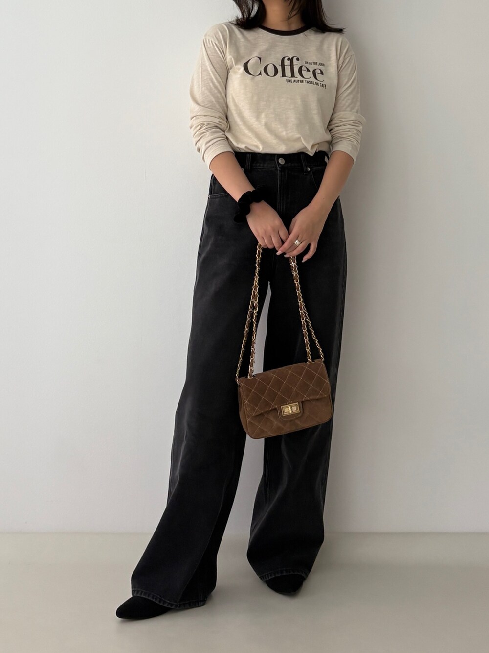 ベージュ系のTシャツ/カットソー、ブラック系のデニムパンツを着用したレディースの秋コーディネートの4枚目の写真