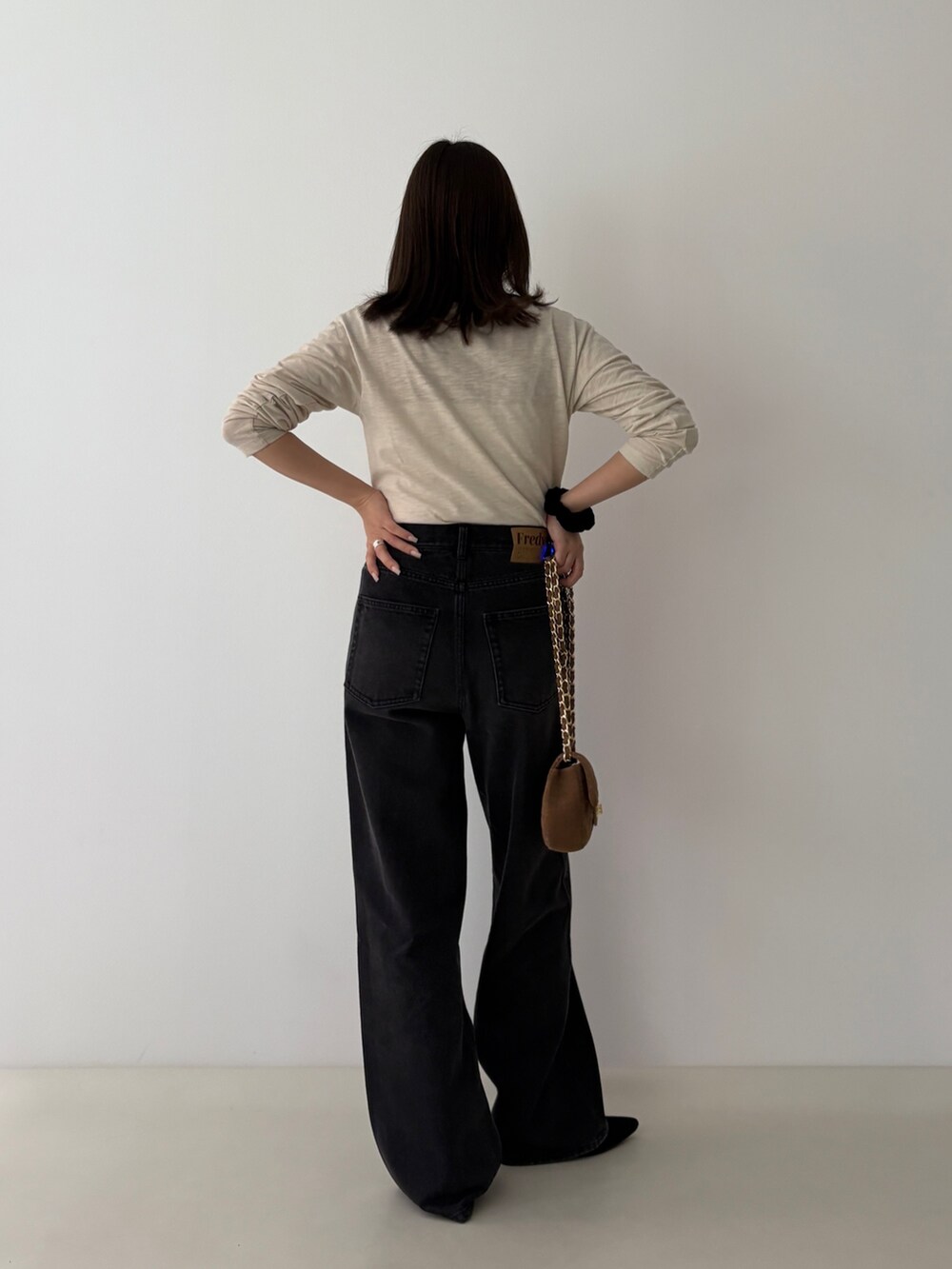 ベージュ系のTシャツ/カットソー、ブラック系のデニムパンツを着用したレディースの秋コーディネートの3枚目の写真