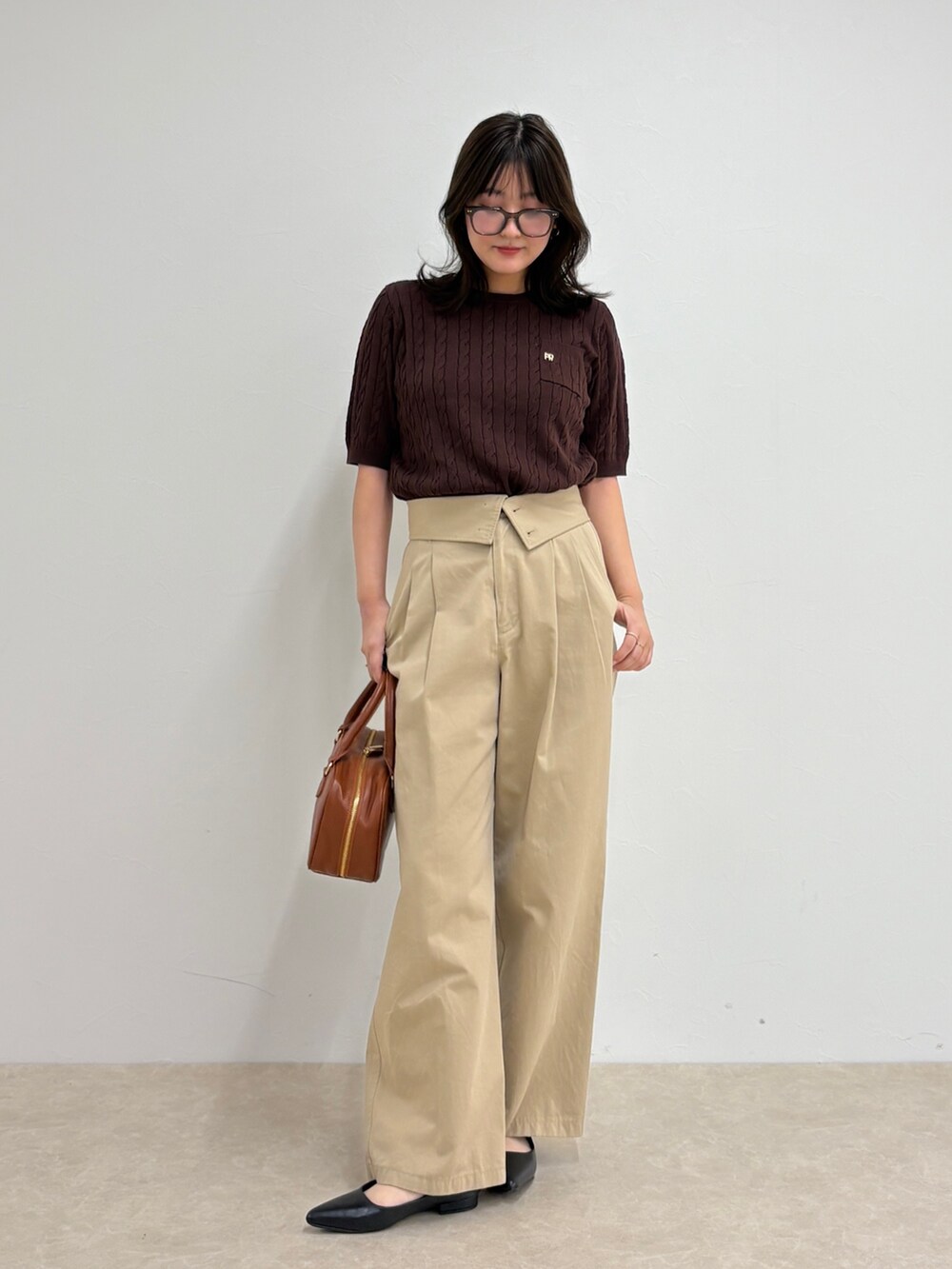 ブラウン系のニット/セーター、ベージュ系のチノパンツ、イエロー系のショルダーバッグを着用したレディースの夏コーディネートの6枚目の写真