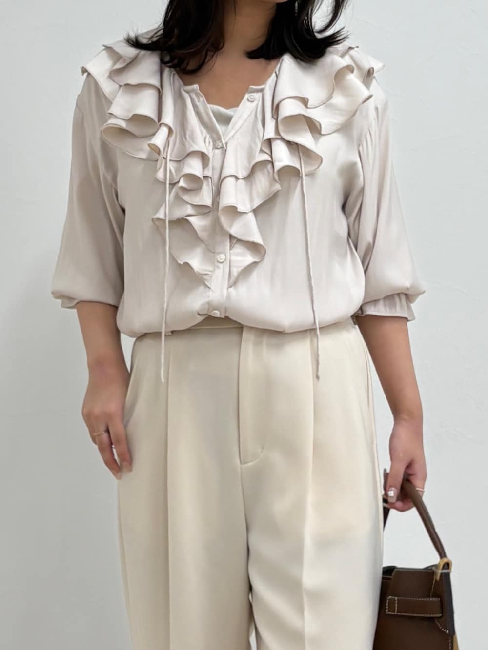 ホワイト系のシャツ/ブラウス、ホワイト系のスラックス、ブラウン系のショルダーバッグを着用したレディースの夏コーディネートの4枚目の写真