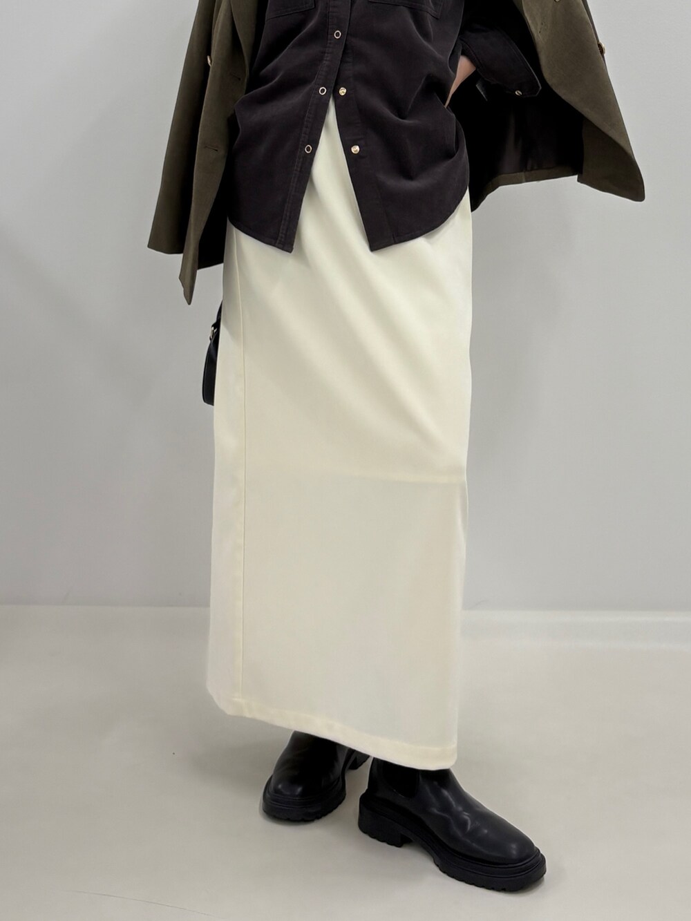 グレー系のシャツ/ブラウス、ブラウン系のテーラードジャケット、ホワイト系のスカートを着用したレディースの秋コーディネートの4枚目の写真