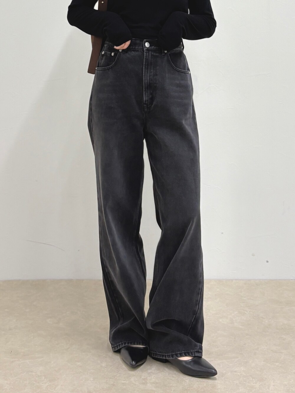 ブルー系のデニムパンツ、ブラック系のTシャツ/カットソー、ブラウン系のショルダーバッグを着用したレディースの夏コーディネートの5枚目の写真