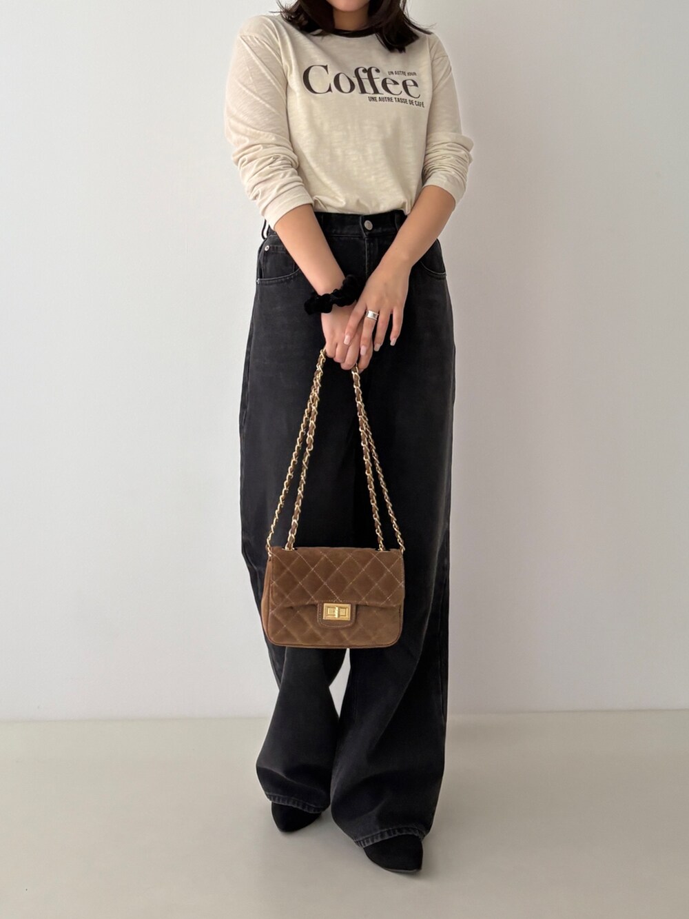 ベージュ系のTシャツ/カットソー、ブラック系のデニムパンツを着用したレディースの秋コーディネートの2枚目の写真