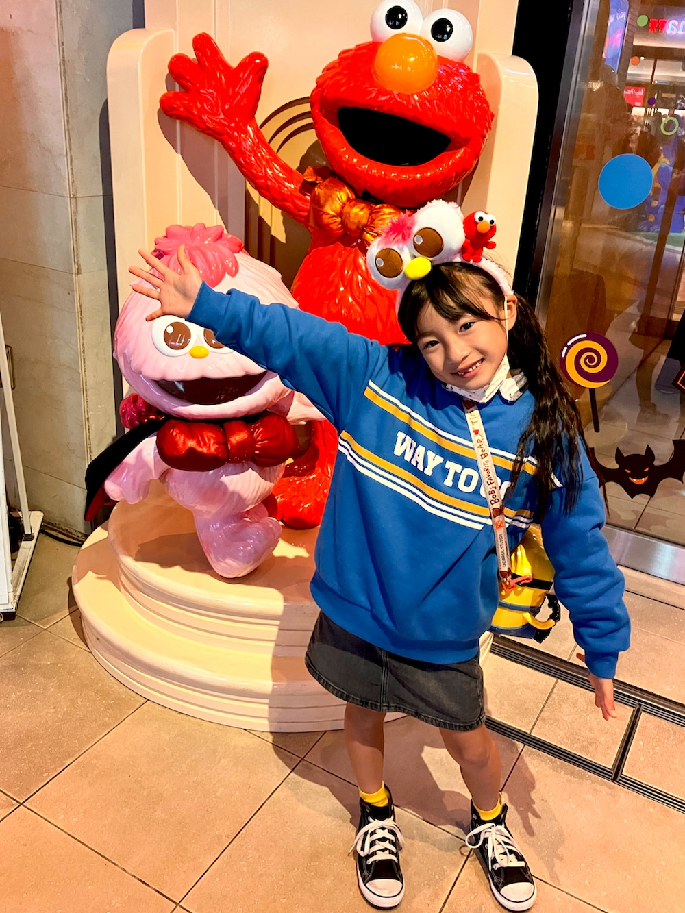 ブルー系のスウェット、ブラック系のデニムスカート、ブラック系のスニーカーを着用したキッズの冬コーディネートの4枚目の写真