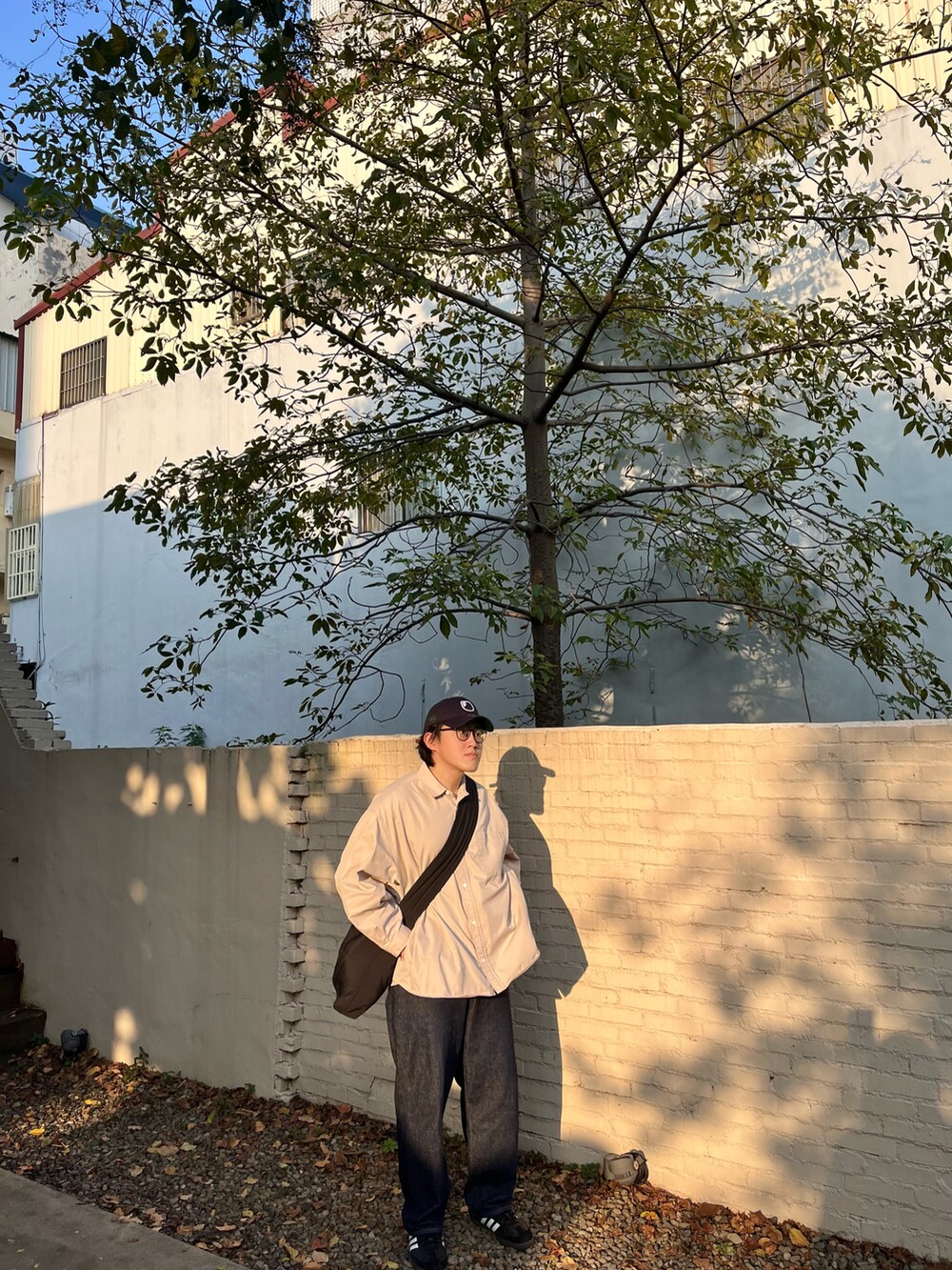 ベージュ系のその他アウター、ブルー系のデニムパンツ、ブラック系のスニーカーを着用したメンズの冬コーディネートの2枚目の写真