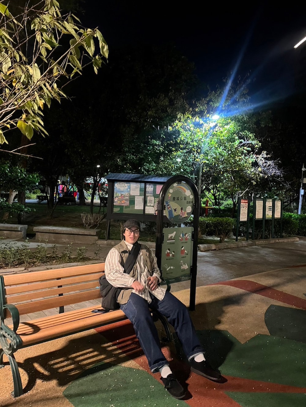 ブラック系のモカシン/デッキシューズ、グリーン系のベスト、ブルー系のデニムパンツを着用したメンズの秋コーディネートの3枚目の写真