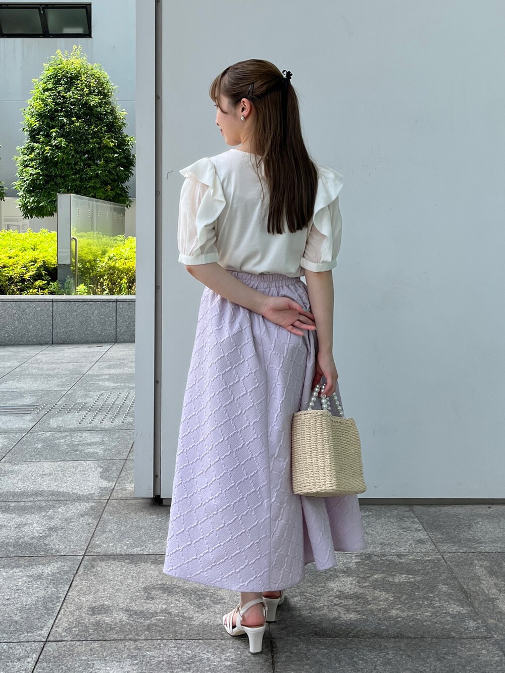 ホワイト系のTシャツ/カットソー、ベージュ系のハンドバッグ、ホワイト系のサンダルを着用したレディースの夏コーディネートの3枚目の写真