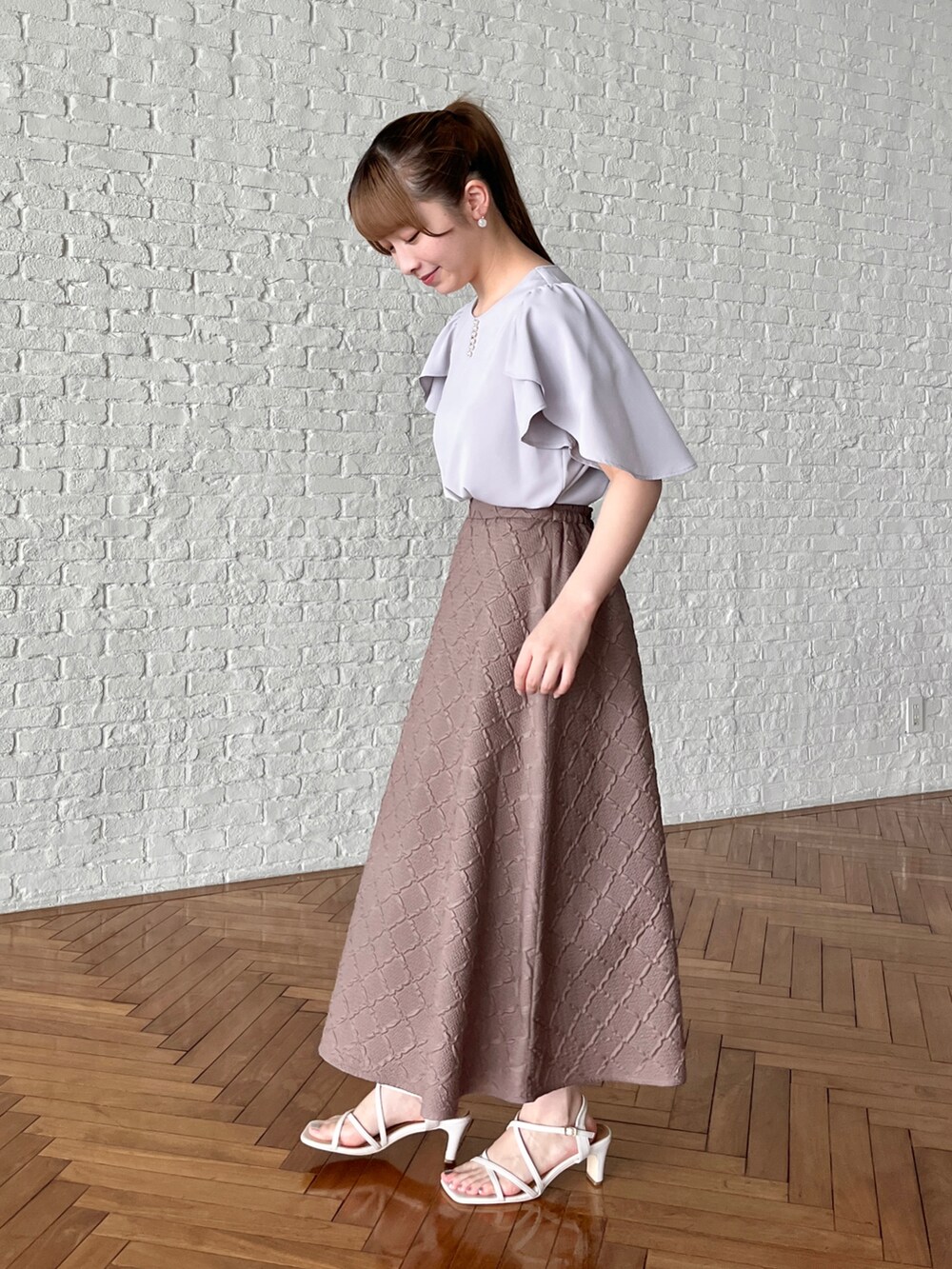 グレー系のシャツ/ブラウス、ブラウン系のスカート、ホワイト系のショルダーバッグを着用したレディースの夏コーディネートの2枚目の写真