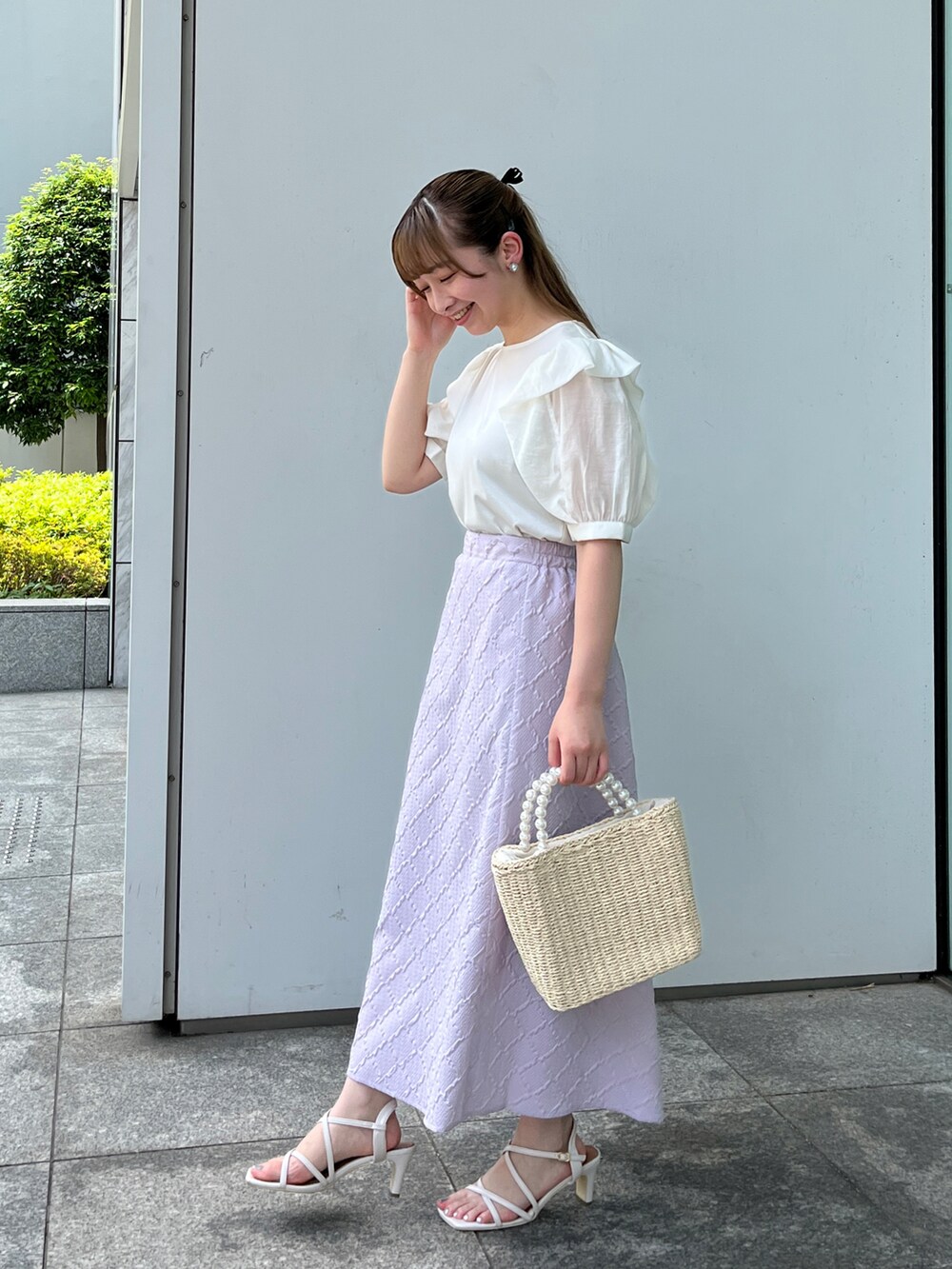 ホワイト系のTシャツ/カットソー、ベージュ系のハンドバッグ、ホワイト系のサンダルを着用したレディースの夏コーディネートの2枚目の写真