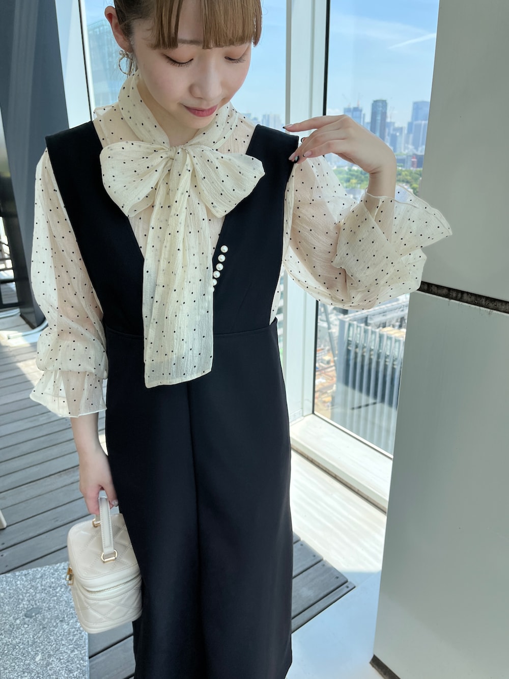 ホワイト系のショルダーバッグ、ベージュ系のワンピースを着用したレディースの秋コーディネートの4枚目の写真