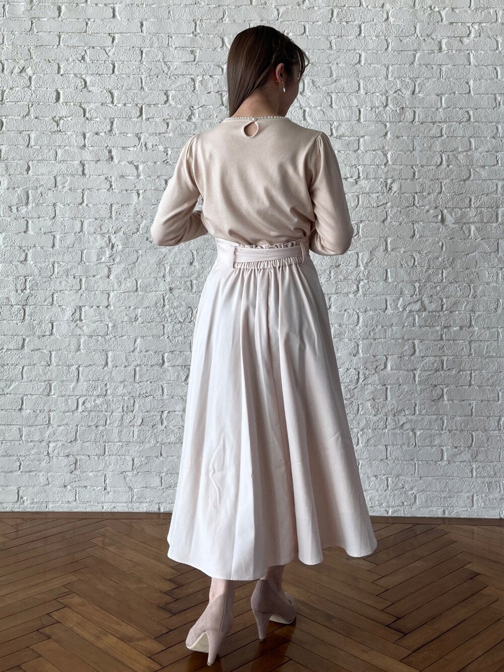 ホワイト系のニット/セーター、ホワイト系のスカート、ベージュ系のパンプスを着用したレディースの冬コーディネートの3枚目の写真