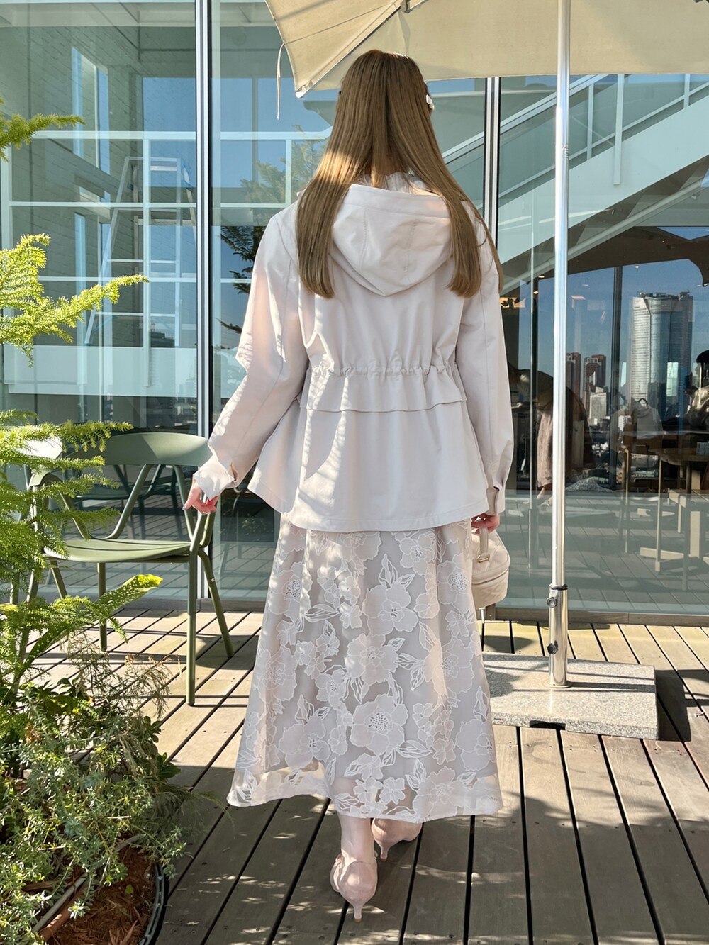 ベージュ系のブルゾン、ホワイト系のニット/セーター、ベージュ系のスカートを着用したレディースの冬コーディネートの2枚目の写真