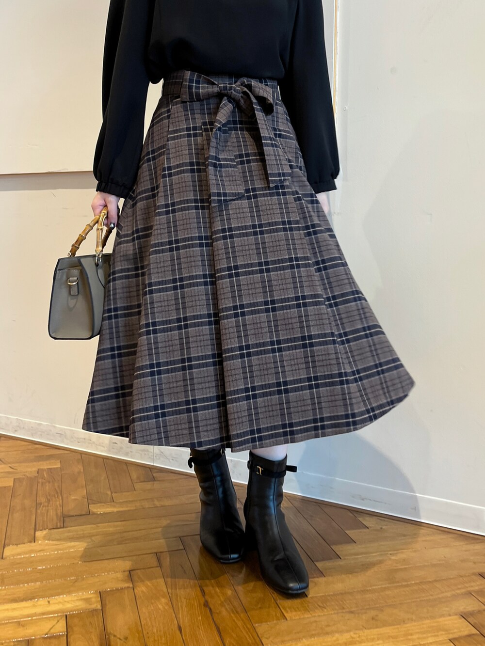 ブラック系のシャツ/ブラウス、ブラウン系のスカートを着用したレディースの秋コーディネートの5枚目の写真