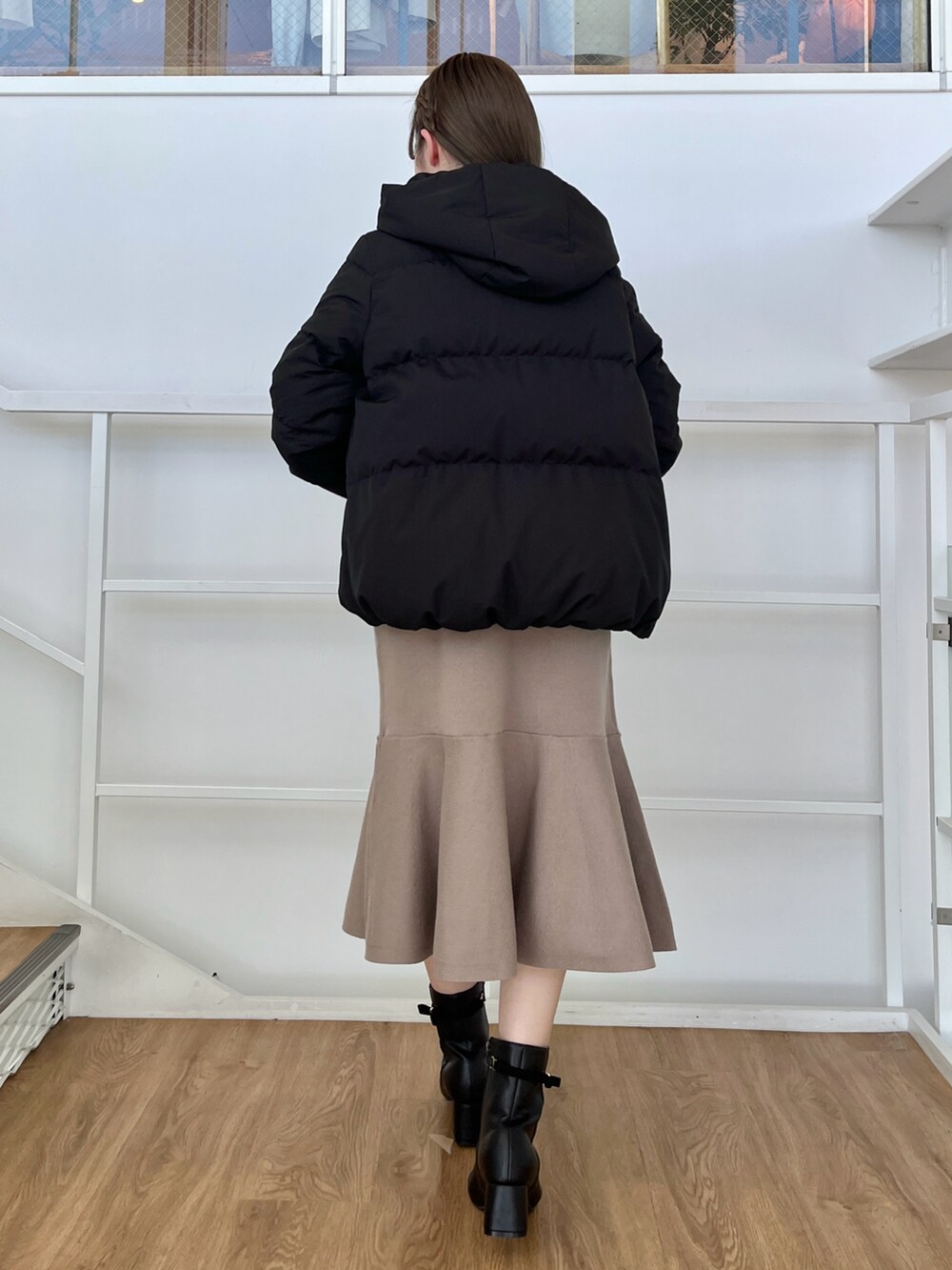 ブラック系のダウンジャケット/コート、ブラウン系のワンピースを着用したレディースの冬コーディネートの2枚目の写真