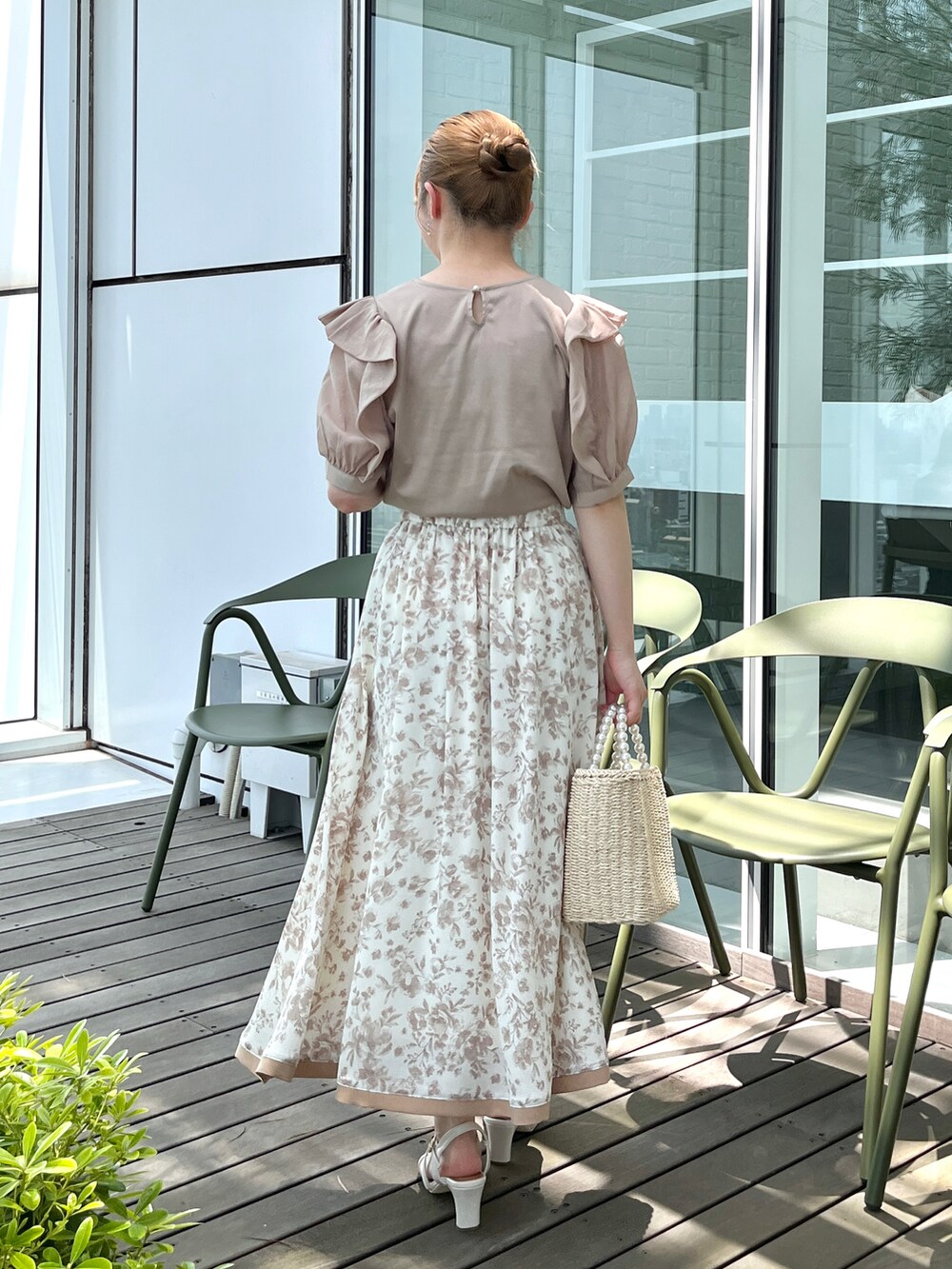 ベージュ系のTシャツ/カットソー、ベージュ系のスカート、ベージュ系のハンドバッグを着用したレディースの夏コーディネートの3枚目の写真