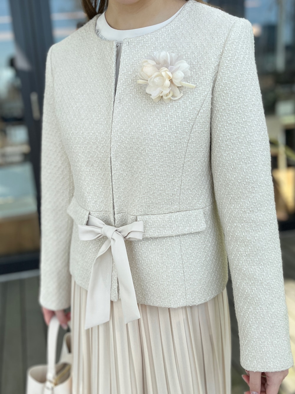 ベージュ系のノーカラージャケット、ホワイト系のスカート、ベージュ系のパンプスを着用したレディースの冬コーディネートの4枚目の写真