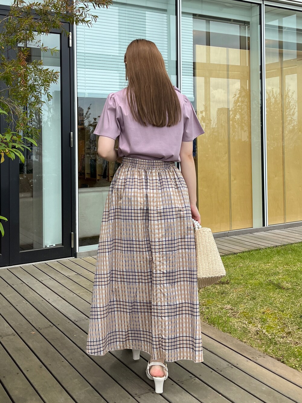 パープル系のTシャツ/カットソー、ベージュ系のスカート、ベージュ系のハンドバッグを着用したレディースの夏コーディネートの3枚目の写真
