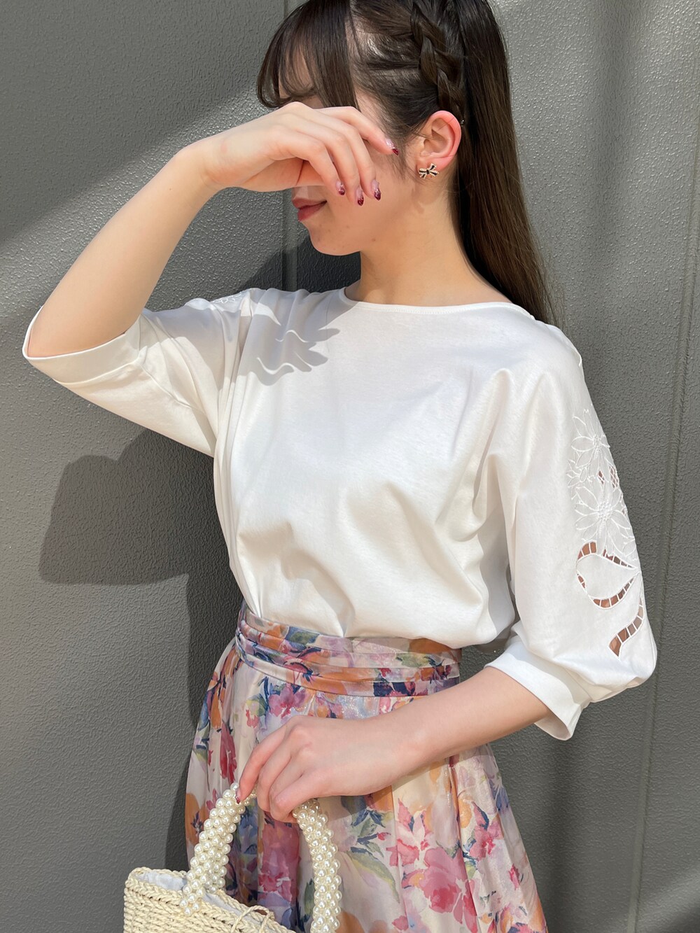 ホワイト系のTシャツ/カットソー、オレンジ系のスカートを着用したレディースの春コーディネートの3枚目の写真