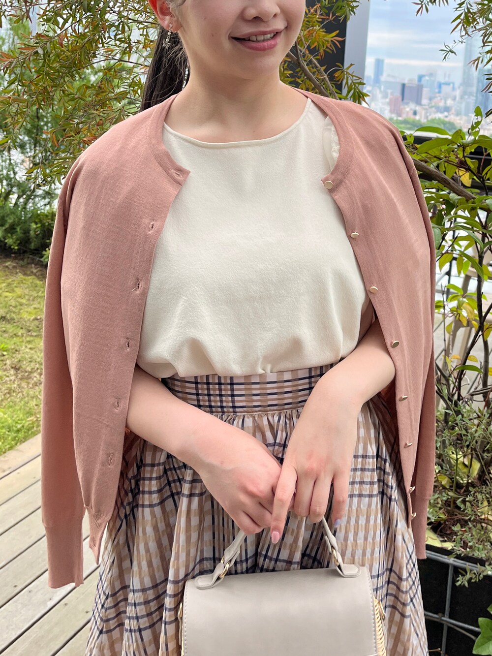 ホワイト系のニット/セーター、グレー系のショルダーバッグ、ホワイト系のサンダルを着用したレディースの夏コーディネートの4枚目の写真