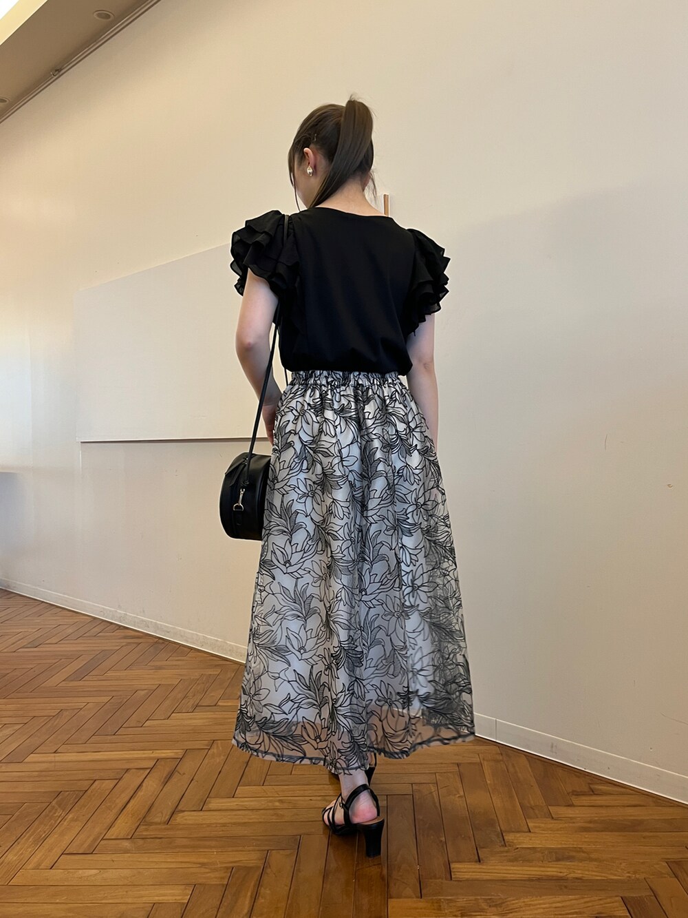 ブラック系のショルダーバッグ、ブラック系のサンダル、ブラック系のスカートを着用したレディースの春コーディネートの3枚目の写真