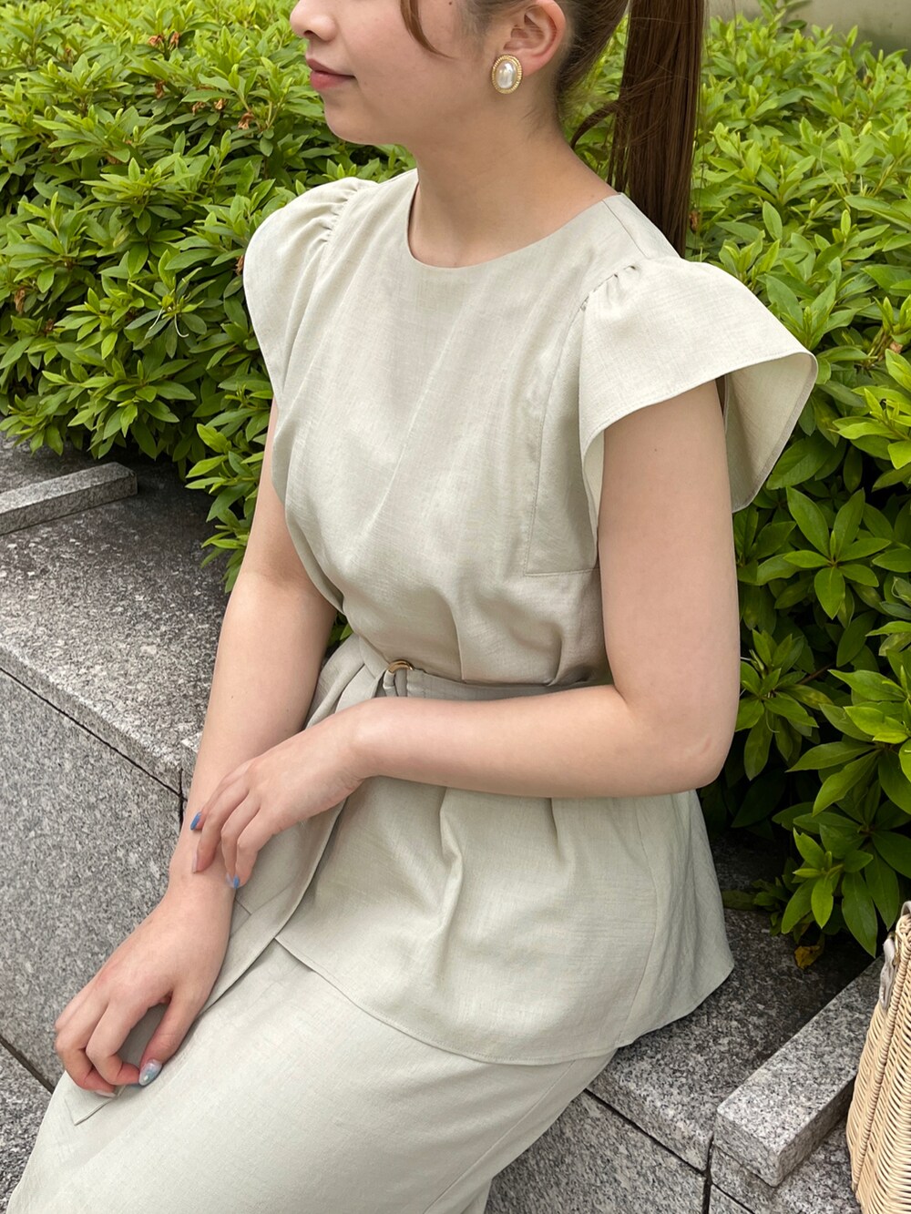 グリーン系のシャツ/ブラウス、グリーン系のスカート、グレー系のショルダーバッグを着用したレディースの春コーディネートの4枚目の写真