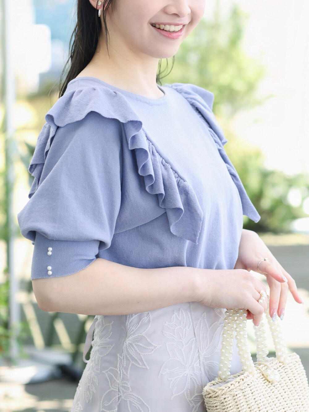 ブルー系のニット/セーター、グレー系のスカートを着用したレディースの春コーディネートの4枚目の写真