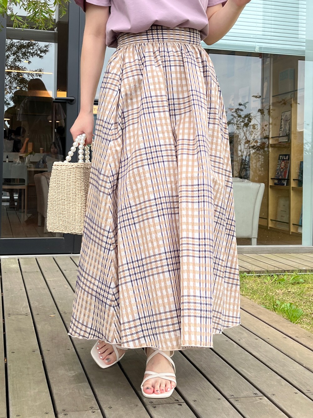 パープル系のTシャツ/カットソー、ベージュ系のスカート、ベージュ系のハンドバッグを着用したレディースの夏コーディネートの5枚目の写真