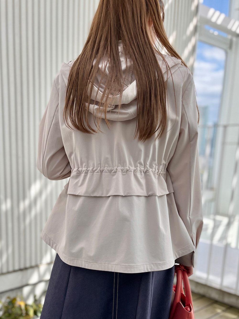 グレー系のブルゾン、ホワイト系のTシャツ/カットソー、ブルー系のスカートを着用したレディースの春コーディネートの4枚目の写真