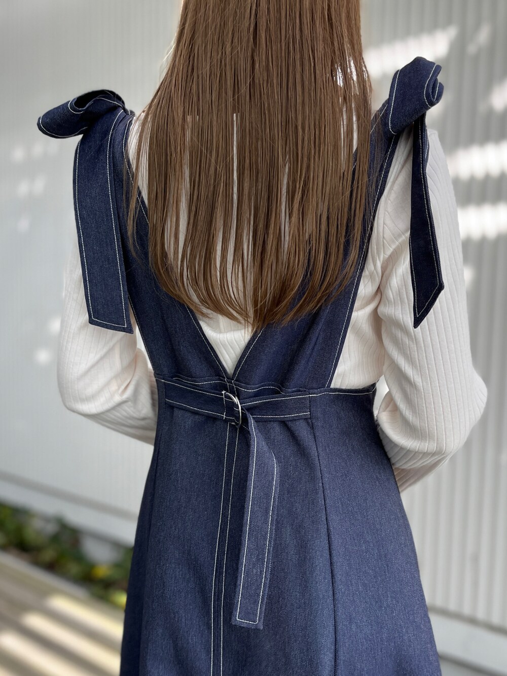 ブルー系のスカート、ホワイト系のTシャツ/カットソー、ピンク系のショルダーバッグを着用したレディースの春コーディネートの4枚目の写真