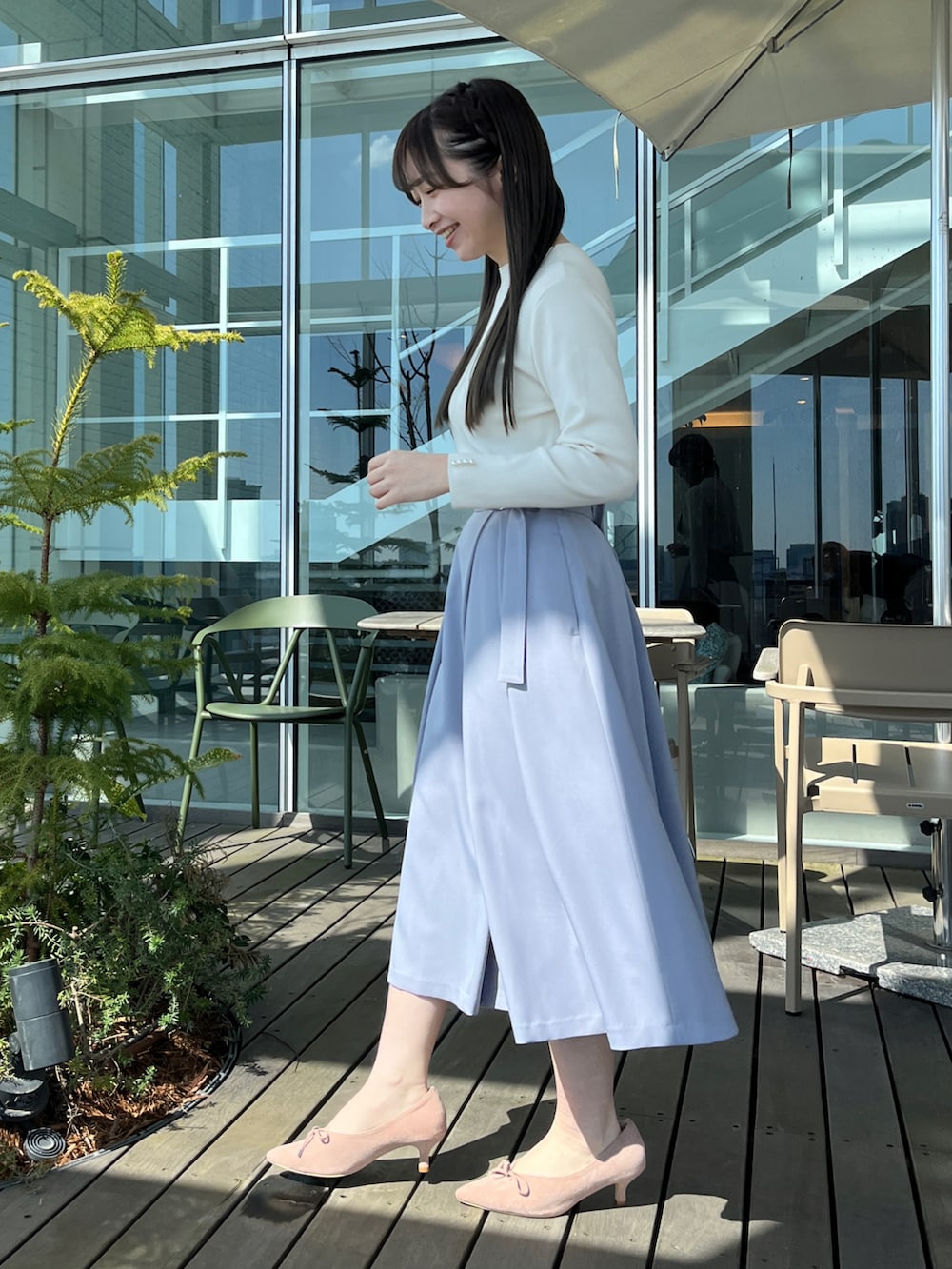 ホワイト系のニット/セーター、ブルー系のスカートを着用したレディースの春コーディネートの2枚目の写真